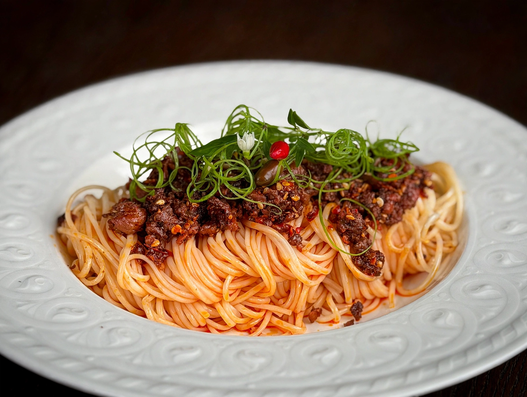 Noodles topped with sauce and greens